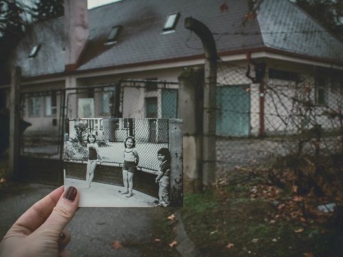 A person holding up an old photograph.