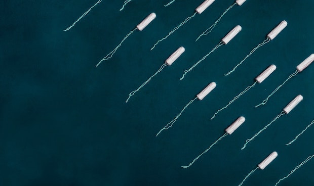 tampons lined up on a dark green background