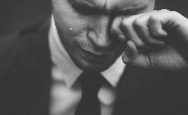 a man in a suit crying