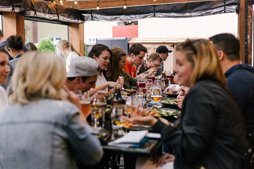 A large group of people eating and drinking at a table.
