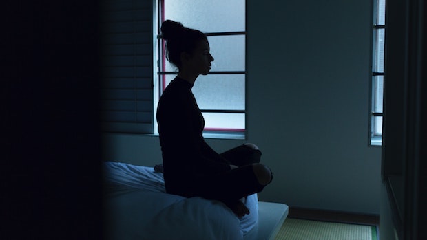 a woman sitting on the edge of a bed